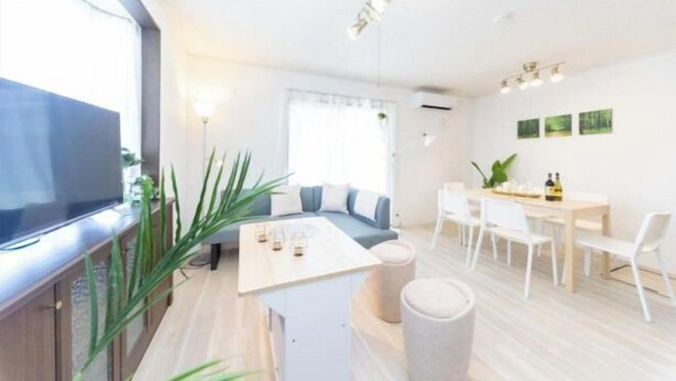 Una sala de estar moderna con sofá, mesa de centro y comedor.
