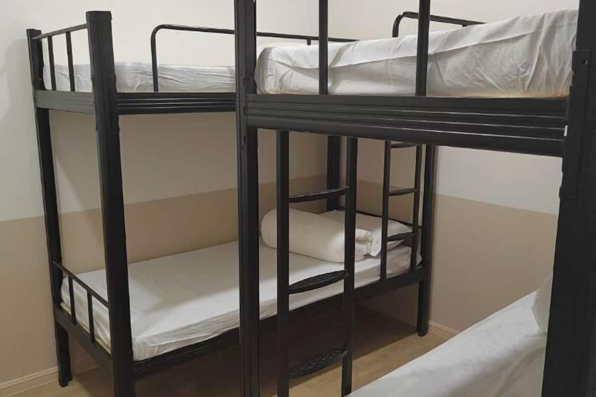 A bunk bed with two levels, each with a mattress and pillows.