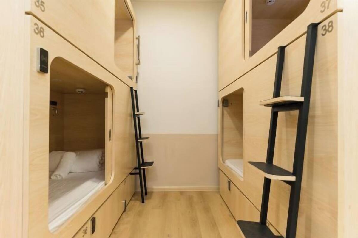 A narrow corridor with bunk beds, each marked with a number.