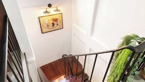 Escada com acabamento em madeira e guarda-corpo em metal preto.