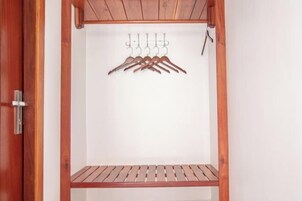 Un placard en bois avec une tringle et une étagère.