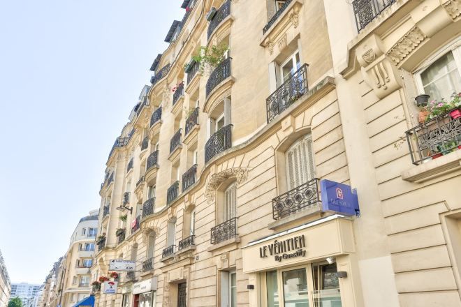 Un immeuble à plusieurs étages abritant un hôtel-boutique appelé «Le Vénitien» au rez-de-chaussée.