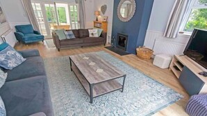 Un salon avec un canapé, une table basse, une cheminée et un téléviseur.