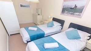 A hotel room with two beds, a nightstand, a dresser, a lamp, and a framed picture on the wall. - Cloudbreak Hot Tub Log Burner, Dogs Welcome (Heanton Punchardon)