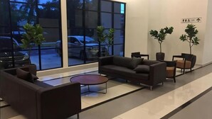 A modern lobby with a sofa, chairs, a coffee table, and large windows. - PLATINO Kids Friendly, 3BR Family Suite, Next to Paradigm Mall Escape JB (Tebrau)