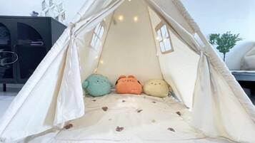 A tent-like structure with a cushioned seating area and a small table with decorative items.