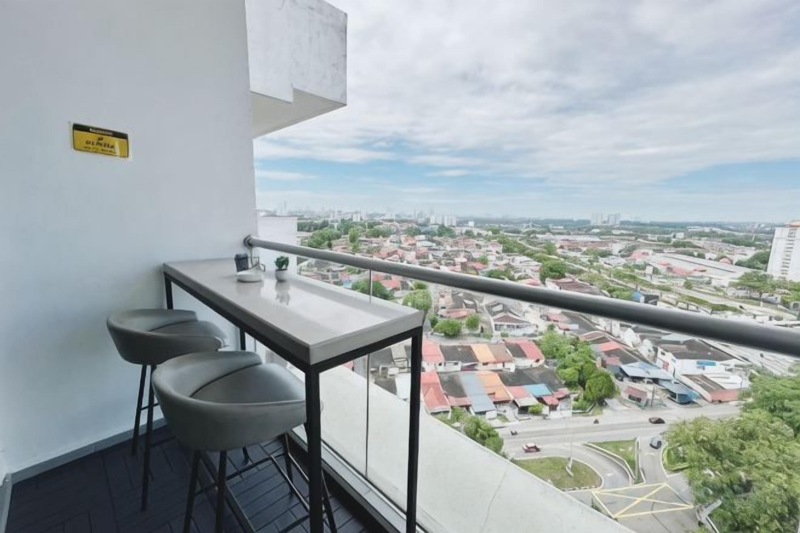 A balcony with a city view, a small table, and two bar stools.