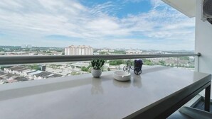 A balcony with a railing, a potted plant, and a bicycle. - PLATINO Kids Friendly, 3BR Family Suite, Next to Paradigm Mall Escape JB (Tebrau)
