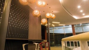 A modern interior with hanging spherical lights, a curved ceiling, and large windows.