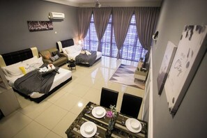 Een moderne hotelkamer met een bed, een bank en een eethoek.