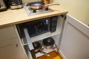 A compact kitchen with a built-in stove, oven, and a small cabinet below. - Rainforest Studio Downtown by Pretty Apartments (Bucharest)