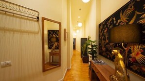A hallway with a wooden bench, a mirror, and a decorative golden statue. - Rainforest Studio Downtown by Pretty Apartments (Bucharest)