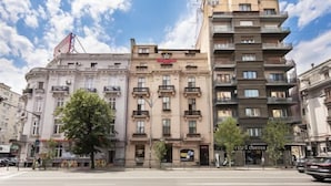 A multi-story building with a mix of residential and commercial spaces, including a visible coffee shop on the ground floor. - Rainforest Studio Downtown by Pretty Apartments (Bucharest)