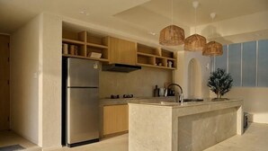 Uma cozinha moderna com ilha integrada, eletrodomésticos de aço inoxidável, armários de madeira e uma janela grande.