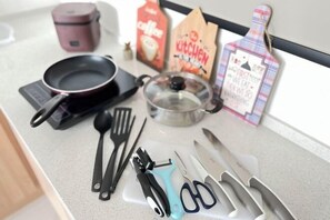 Un plan de travail de cuisine avec divers ustensiles, une machine à café, une bouilloire et un paquet de café.