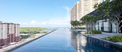 Una piscina larga con vistas a un paisaje urbano y vegetación.