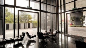 A modern interior with large windows, black chairs, and a polished floor. - Georgetown Urban Suite Family Skypool I SeaView (Jelutong)