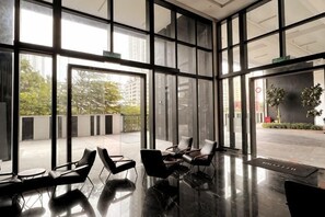 Un intérieur moderne avec de grandes fenêtres, des chaises noires et un plancher poli.