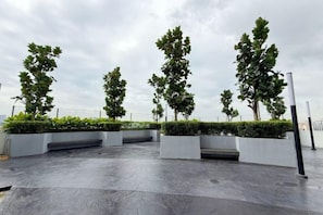 A paved outdoor area with planters and trees. - Nexus Kajang by Luvit Stay (Kajang)