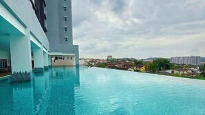 A swimming pool with a view of a cityscape, including buildings and a distant mountain. - Nexus Kajang by Luvit Stay (Kajang)