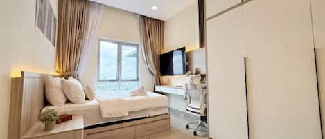 Un dormitorio moderno con cama, escritorio y televisión.