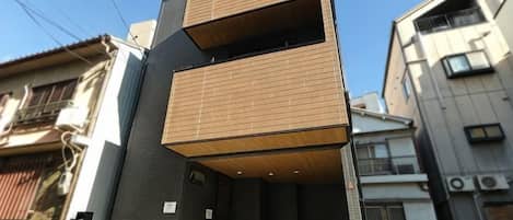 Un edificio de varios pisos con techo plano y balcón.