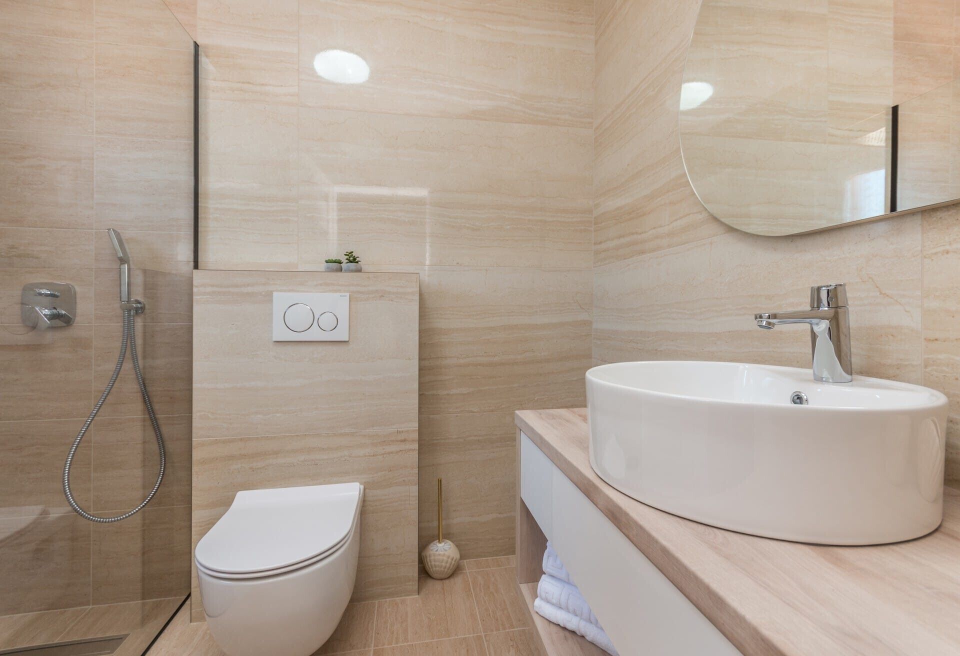 A modern bathroom with a toilet, a sink, and a shower.
