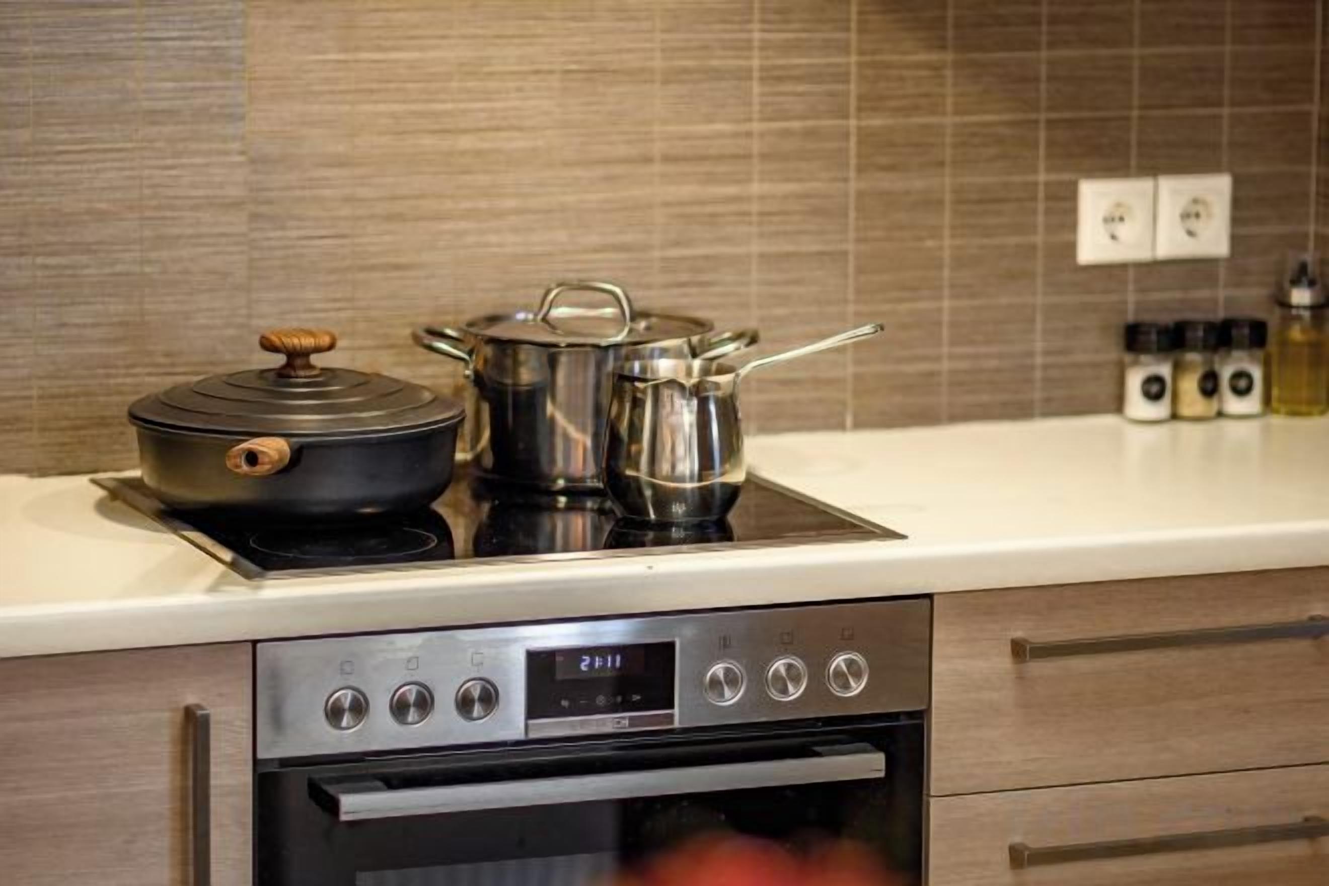 Une cuisine équipée d’une cuisinière, d’un four et de casseroles.