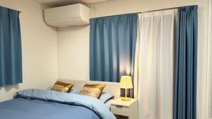 Une chambre d’hôtel avec un lit, une table de chevet avec une lampe et des rideaux.