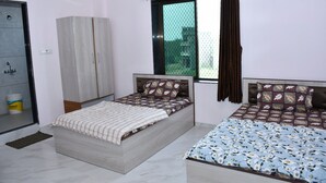 Un dormitorio con dos camas, un armario, una ventana con cortinas y vistas al exterior.