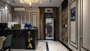 A hotel lobby with a reception desk labeled 'SPA,' a marble floor, and a modern interior design. - Marco Polo (Tashkent)