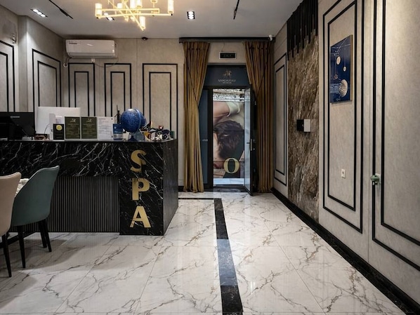 A hotel lobby with a reception desk labeled 'SPA,' a marble floor, and a modern interior design. - Marco Polo (Tashkent)