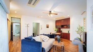 A modern living room with a sofa, a coffee table, and a ceiling fan. - Skyview Serenity Duplex Shinjuku (Tokyo)