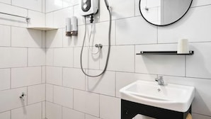 A modern bathroom with white tiles, a black sink, a handheld showerhead, a towel rack, and a mirror. - Ipoh South Homestay 8-16pax 10mins to attraction (Ipoh)