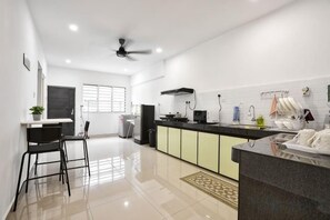 A modern kitchen with a black countertop, a ceiling fan, and a window with blinds. - Ipoh South Homestay 8-16pax 10mins to attraction (Ipoh)