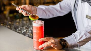 Een bartender bereidt een cocktail met een limoen.