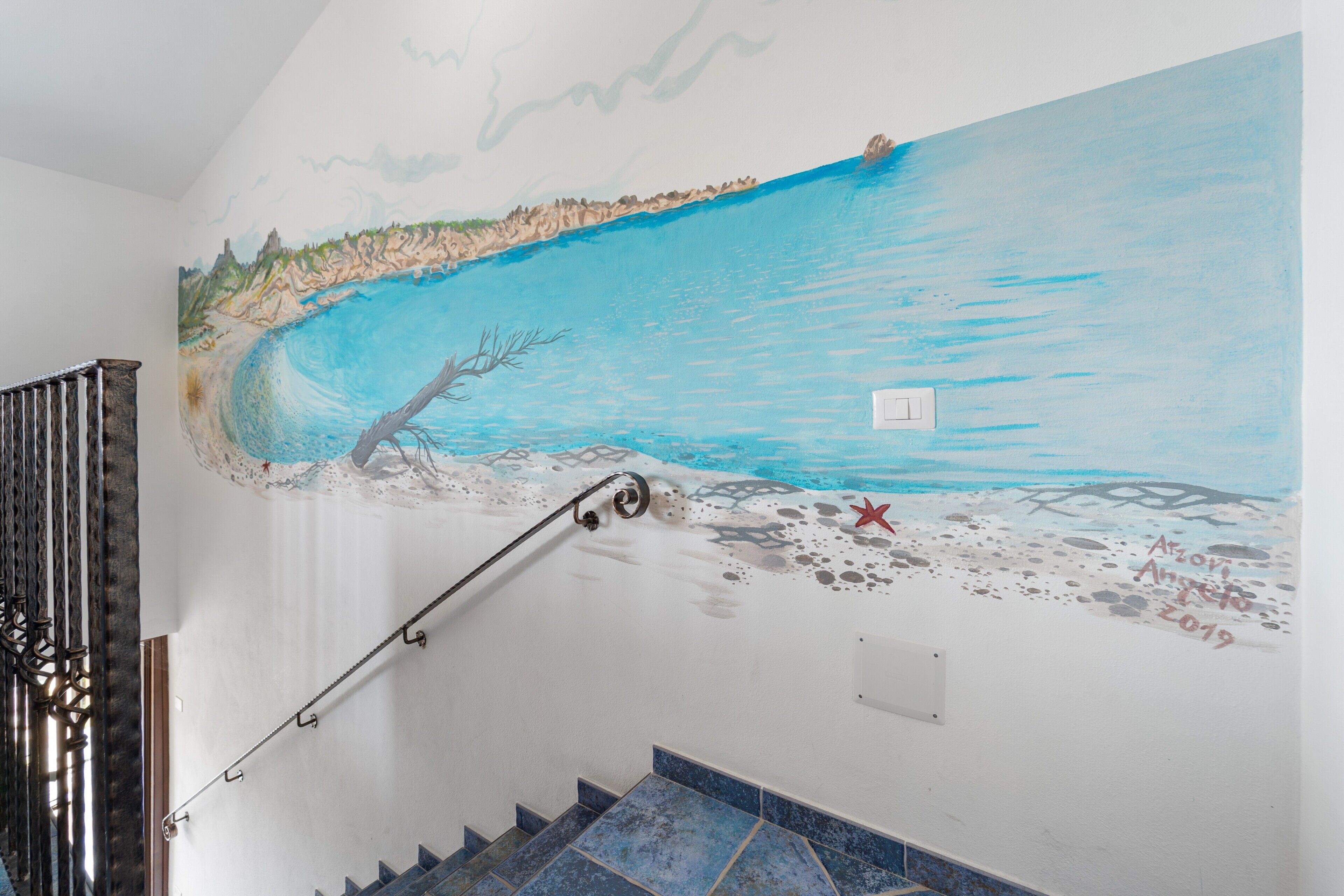 Eine Treppe mit einem Wandgemälde, das eine Strandansicht zeigt.