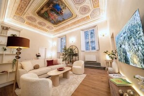 Een ruime woonkamer met een hoge plafond, een groot schilderij en een zithoek.