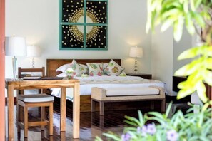 A bedroom with a bed, bedside tables, a chair, and a wall art piece. - Baan Chang (Koh Samui)
