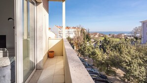 A balcony with a view of a residential area, a tiled floor, and a potted plant. - Jambul Apartment, Graça, Lisbon (Lisboa)