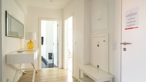 A hallway with a white desk, a yellow vase, and a bench. There are doors leading to other rooms. - Jambul Apartment, Graça, Lisbon (Lisboa)