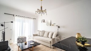 A modern living room with a sofa, a coffee table, and a dining table. - Jambul Apartment, Graça, Lisbon (Lisboa)