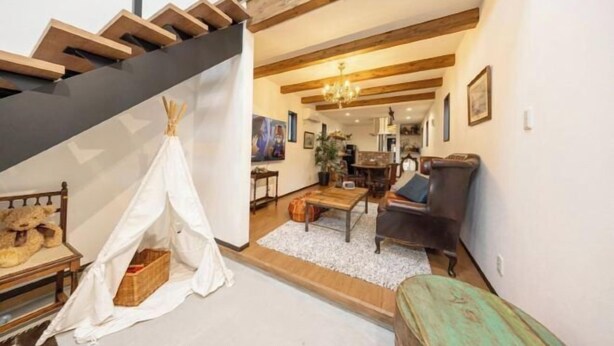 A staircase with wooden beams, a living room with a sofa, a coffee table, and a tent-like structure. - 【Antiques Gifu Station East】Entire Villa for up to 10 Guests 10-Min Walk from JR Gifu Station (Gifu)