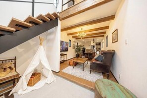A staircase with wooden beams, a living room with a sofa, a coffee table, and a tent-like structure. - 【Antiques Gifu Station East】Entire Villa for up to 10 Guests 10-Min Walk from JR Gifu Station (Gifu)