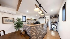 A modern kitchen with a brick island, wooden dining table, and pendant lighting. - 【Antiques Gifu Station East】Entire Villa for up to 10 Guests 10-Min Walk from JR Gifu Station (Gifu)