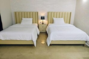 A double room with two beds, each with a headboard and a bedside table with a lamp. - kunlunjiudian (Lahore)