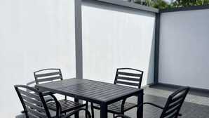 A patio with a table and chairs, surrounded by white walls. - TJ POOL VILLA AONANG KRABI (Krabi)