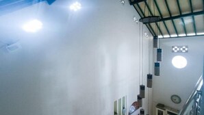 A staircase with a metal railing, a white wall, and hanging lanterns. - Vj Sweethome Syariah Near GOR Turida (Turida)