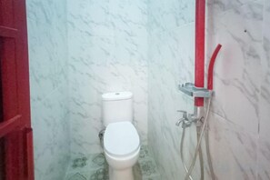 A bathroom with a toilet, a shower area, and a red door. - Vj Sweethome Syariah Near GOR Turida (Turida)
