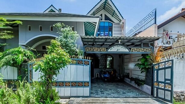 A traditional house with a gated entrance, a covered porch, and a small garden area. - Vj Sweethome Syariah Near GOR Turida (Turida)
